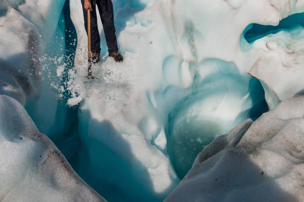 istock Guide to break the glaciers, Walking through glacier tunnel with guide using ice pick. Fox Glacier, New Zealand. 666375298