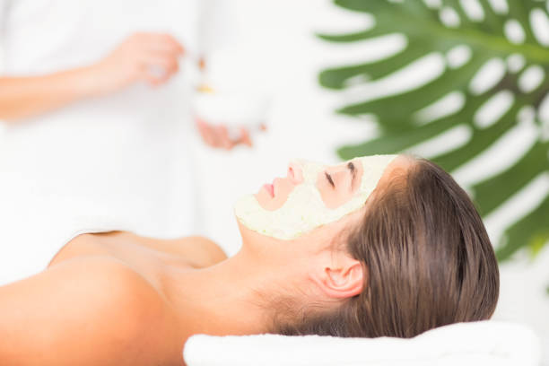 istock Attractive having white cream on her face at spa center 666375354