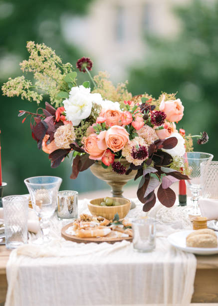 istock Wedding decor. Perfectly decorated holiday table for two with beautiful flower composition of fresh flowers in a vintage vase, red candles, thinly cut jamon, green olives and fresh bread 666376586