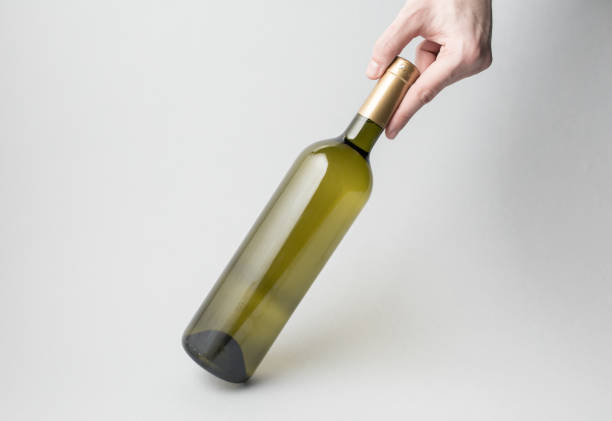 istock Hand is holding wine bottle on gray background 666377232