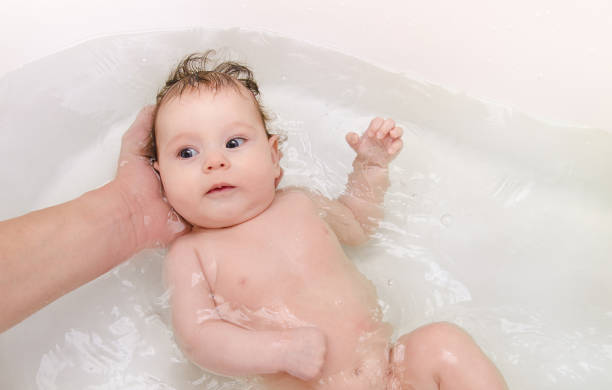istock Newborn baby girl taking a bath  with ducks 666378160
