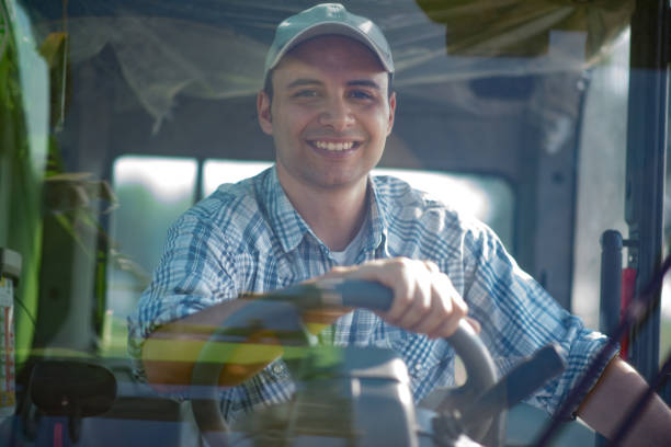 istock Smiling farmer driving an harvesting machine 666379890