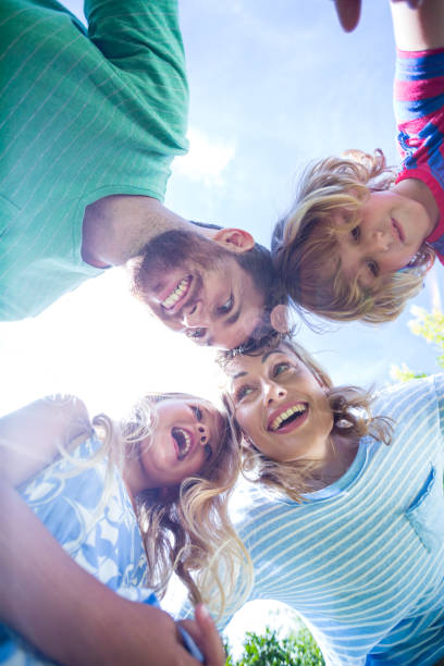 istock Happy family forming huddle in yard 666385782