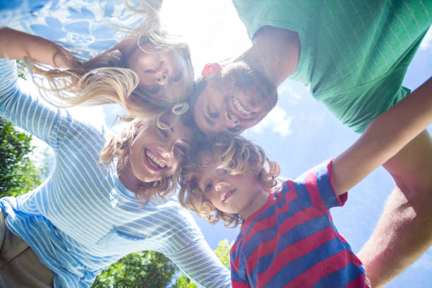 istock Happy parents with children forming huddle at yard 666385840