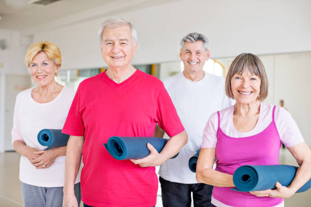 istock Confident senior friends holding exercise mats 666387840