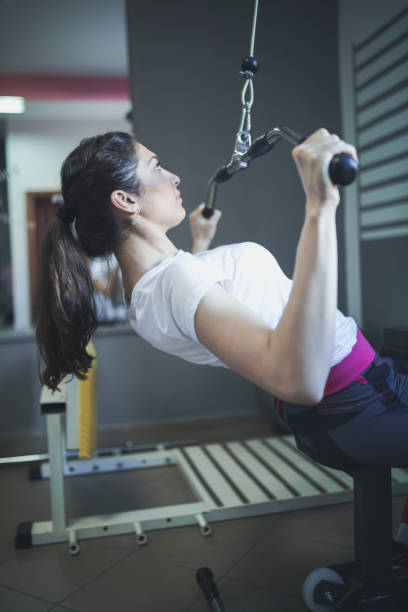 istock young fitness woman execute exercise with exercise-machine in gym 666387938