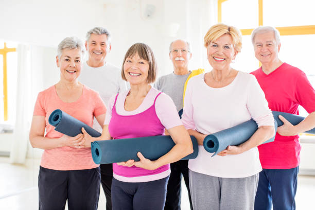 istock Happy senior friends holding exercise mats 666387946