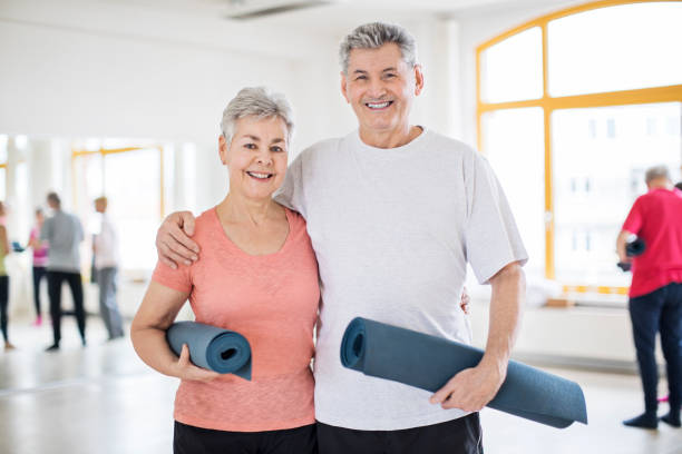 istock Happy senior couple holding exercise mats 666388338