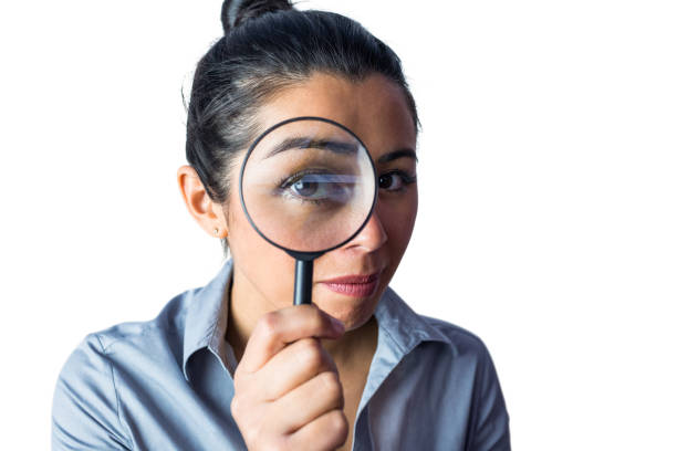 istock Woman examining with a magnifying glass 666388360