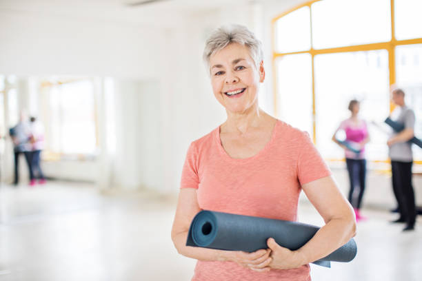 istock Smiling senior woman with exercise mat in class 666388372