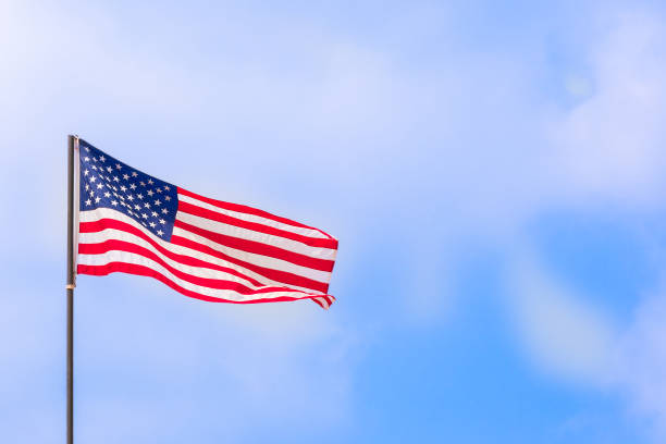 istock American flag waving under the blue sky and clouds 666388452