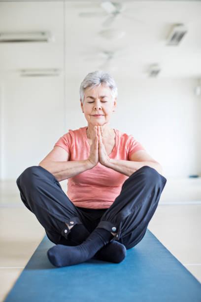 istock Senior woman meditating in yoga class 666388806