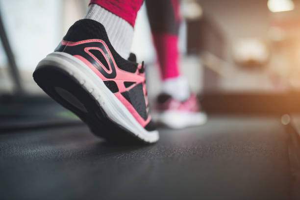 woman's muscular legs on treadmill, closeup
