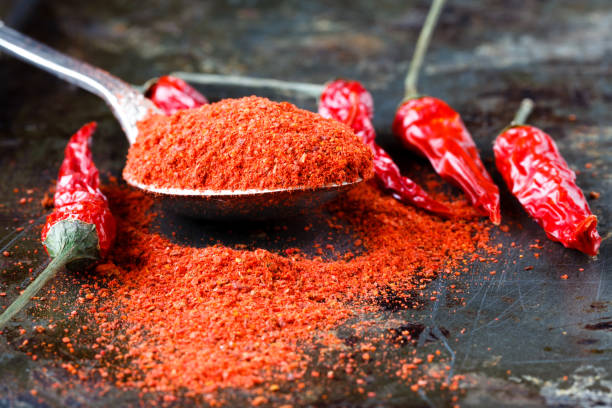 istock Ground chili pepper in a spoon on a dark background, macro shot, selective focus 666393786