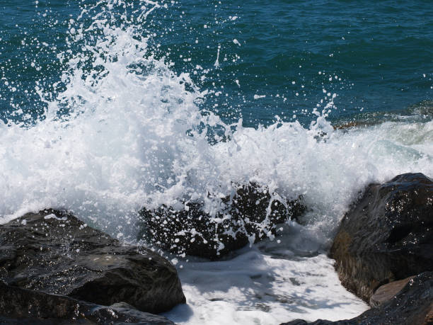 istock Sea wave crashing rocks on the beach 666394238
