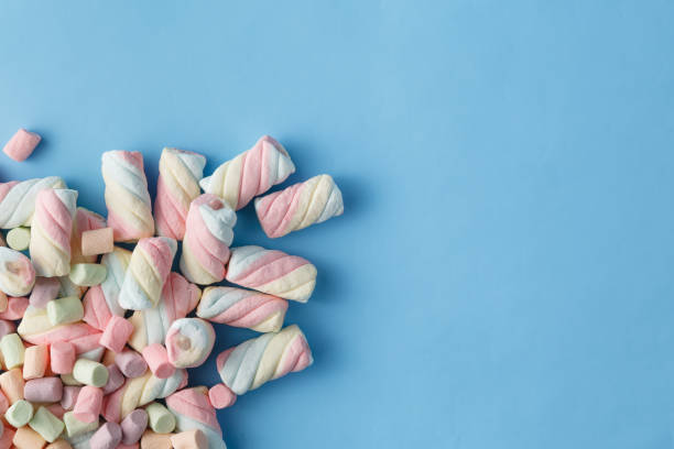 istock Rainbow color of spiral marshmallows on blue background 666395138