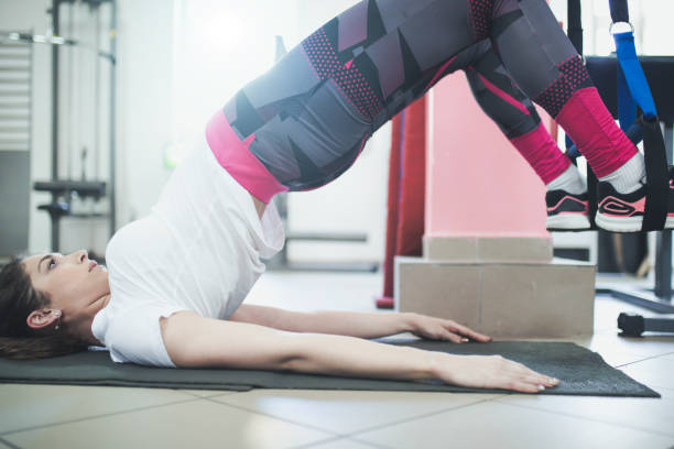 istock Attractive young woman is doing plank exercise while working out in gym 666396360