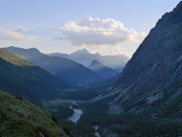 istock Sunset mountain valley with small river and steep mountains 666470516