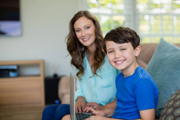 istock Portrait of smiling mother and son sitting on sofa using laptop 666473024