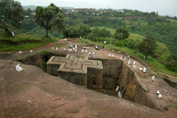 Sunday at St George rock hewn church LALIBELA, ETHIOPIA - 26 AUGUST 2007 - Pilgrims gather at the top of a rock hewn church to pray on a sunday. Although services are carried out through out Lalibela each day, Sundays turn out the greatest local crowds. Many of these pilgrims have relocated to lalibela due to its religious roots. the church of saint george lalibela ethiopia stock pictures, royalty-free photos & images