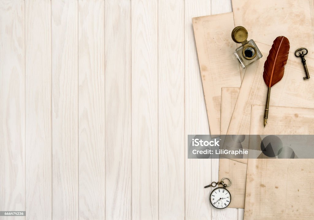 Used paper sheets vintage office supplies wooden table Used paper sheets and vintage office supplies on wooden table. Feather pen and inkwell Desk Stock Photo