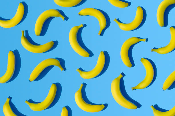 bananas en fondo azul - plátano fruta tropical fotos fotografías e imágenes de stock