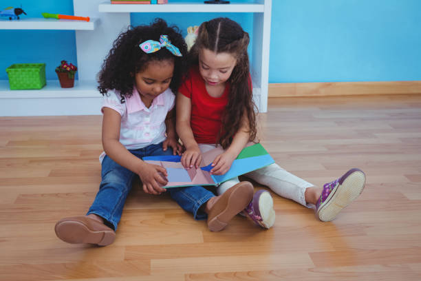 istock Cute girls holding a book 666477452