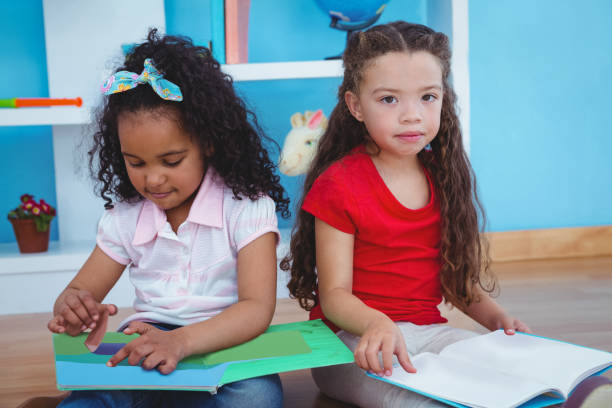istock Cute girls holding books 666477572