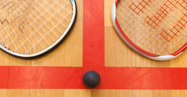 istock squash ball between two squash rackets on the court 666477634