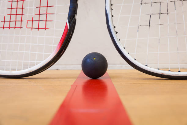 istock squash ball between two squash rackets on the court 666477670