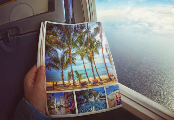 Woman is sitting   by window on a plane with magazine in hands