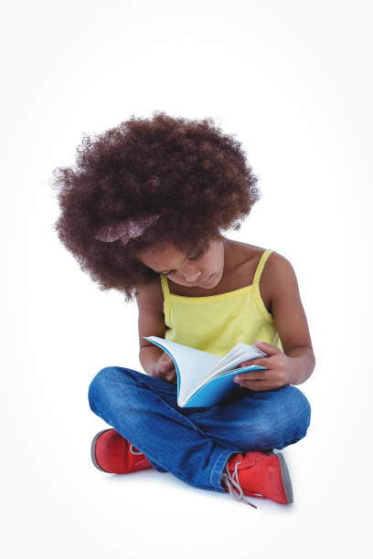 istock Cute girl sitting on the floor holding book 666480582