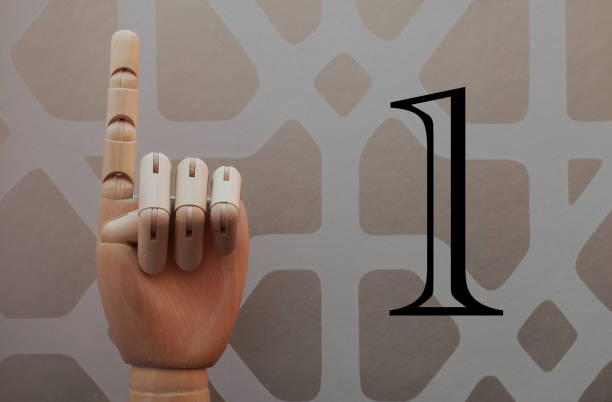 istock Wooden hand with a raised finger next to number one 666486304