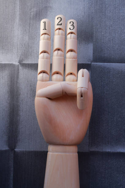 istock Wooden hand with three fingers raised and numbered with numbers one, two and three 666486324