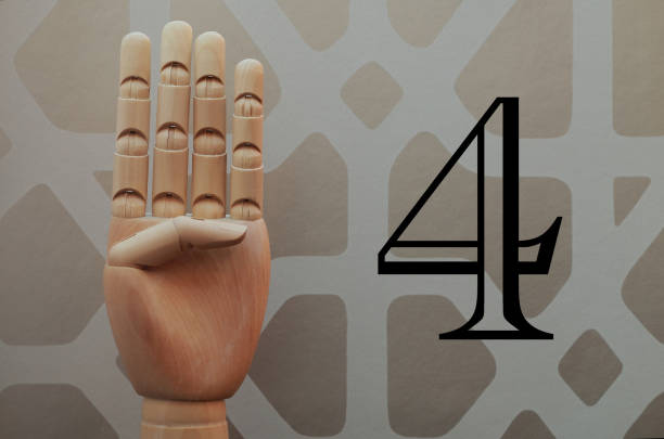 istock Wooden hand with four fingers raised next to number four 666486334