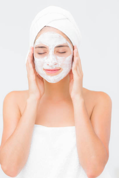 istock Attractive woman having white cream on her face at spa center 666503932
