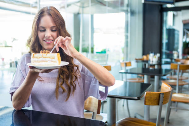 istock Pretty brunette enjoying a cake 666506858