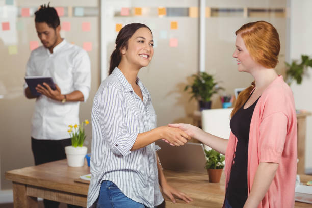 istock Happy businesswomen shaking hands in office 666516986