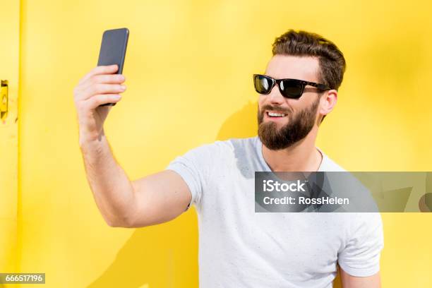 Photo libre de droit de Portrait Dun Homme Sur Fond Jaune banque d'images et plus d'images libres de droit de Lunettes de soleil - Lunettes de soleil, T-Shirt, Selfie