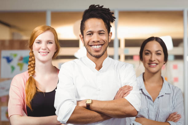 istock Businessman with female colleagues standing with arms folded 666520276