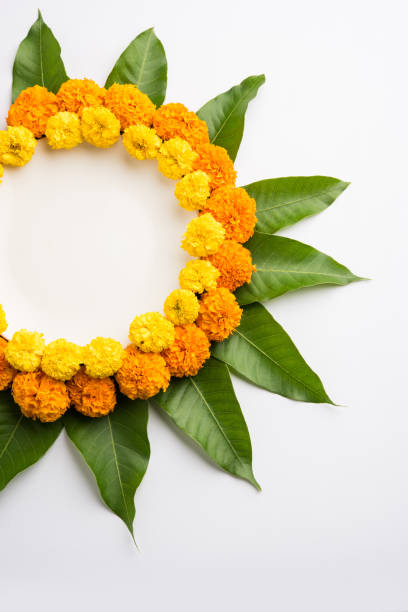 istock flower rangoli made using marigold or zendu flowers and mango leaves over black background with copy space in the middle, selective focus 666520280
