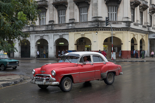Havana, Cuba-January 29, 2017:Antique car driving on the street.A red vintage car in the middle of the street.