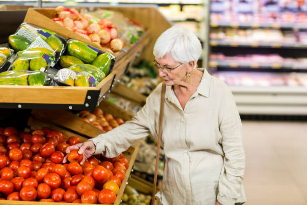 istock Senior woman choosing her tomatoes 666526904