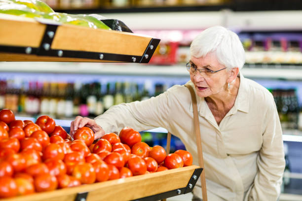 istock Senior woman choosing her tomatoes 666526942