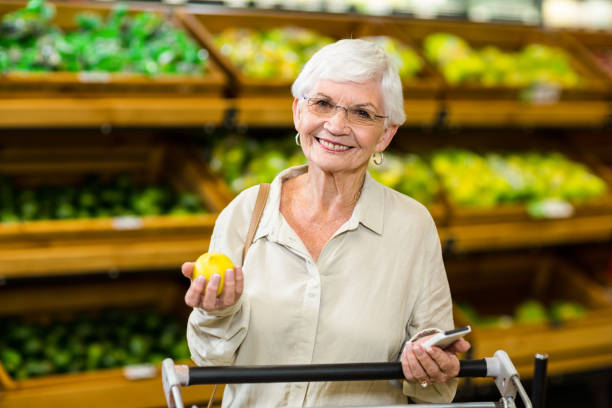 istock Senior woman holding phone and an apple 666527256