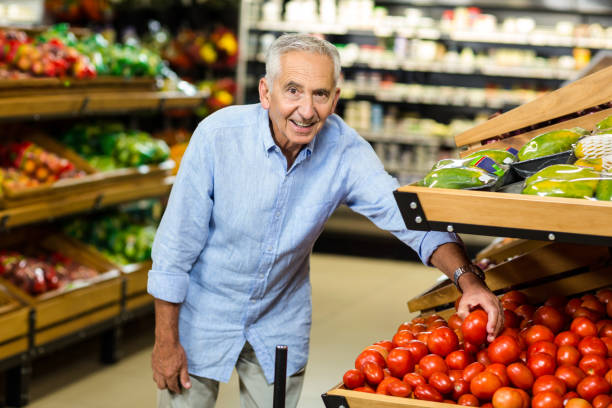 istock Senior man choosing tomato carefully 666529610