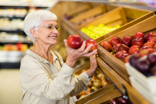 istock Senior woman picking out red apple 666529680