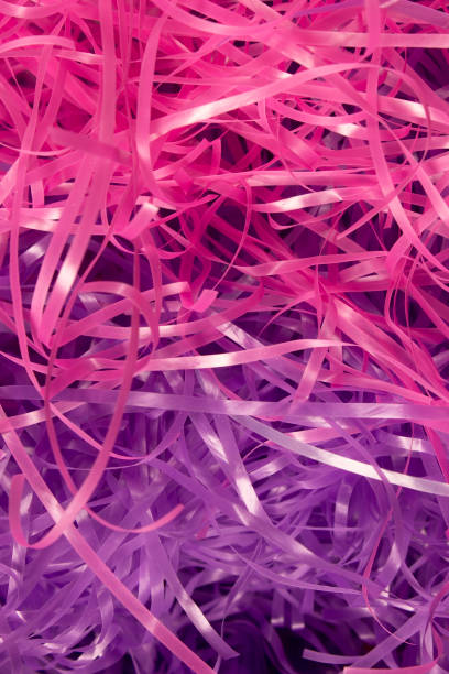 istock Pink and Purple shredded plastic fake Easter grass background 666530340