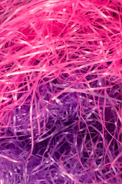 istock Pink and Purple shredded plastic fake Easter grass background 666530344