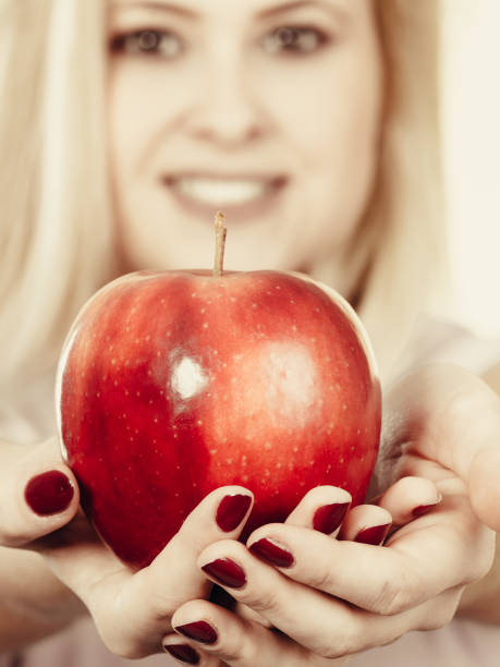 istock Happy woman holding delicious red apple 666539318